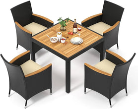 Modern rattan garden furniture set placed in a lush green backyard with soft lighting.