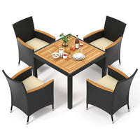 Modern rattan garden furniture set placed in a lush green backyard with soft lighting.