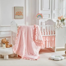 baby bedding draped over a crib in a cozy nursery.