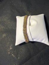 Bronze cross bracelet on metal beaded band.