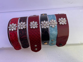 Embossed leather bracelets with clear rhinestone jewel in a floral pattern