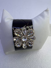 Embossed leather bracelets with clear rhinestone jewel in a floral pattern
