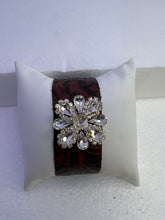 Embossed leather bracelets with clear rhinestone jewel in a floral pattern