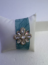 Embossed leather bracelets with clear rhinestone jewel in a floral pattern