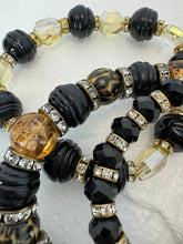 Set of 3 beaded bracelets in black and shades of gold plus leopard patterns