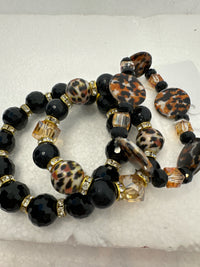 Set of 3 beaded bracelets in black and shades of gold plus leopard patterns