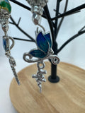 Crosses that say faith and have a butterfly on them adorned with blue cloisonné beads