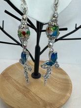 Crosses that say faith and have a butterfly on them adorned with blue cloisonné beads