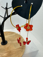 Gold 1 3/4 inch hoops with flower adornment and dangling butterfy