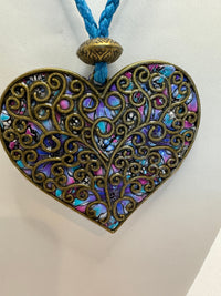 Bronze filigree heart clay filled with patterned clay and on a leather braided cording necklace