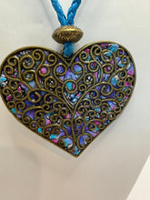 Bronze filigree heart clay filled with patterned clay and on a leather braided cording necklace