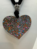 Silver filigree heart clay filled with patterned clay and on a black velvet necklace