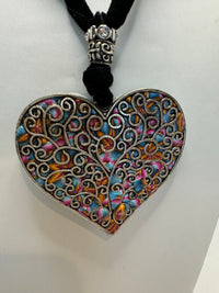 Silver filigree heart clay filled with patterned clay and on a black velvet necklace