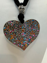 Silver filigree heart clay filled with patterned clay and on a black velvet necklace