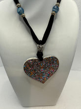 Silver filigree heart clay filled with patterned clay and on a black velvet necklace