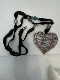 Silver filigree heart clay filled with patterned clay and on a black velvet necklace