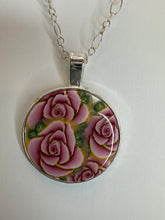 Round pendants filled with patterned polymer clay in various colors on dainty coordinated chains