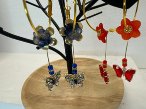 Gold 1 3/4 inch hoops with flower adornment and dangling butterfy