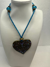 Bronze filigree heart clay filled with patterned clay and on a leather braided cording necklace