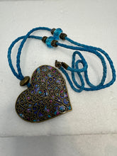Bronze filigree heart clay filled with patterned clay and on a leather braided cording necklace
