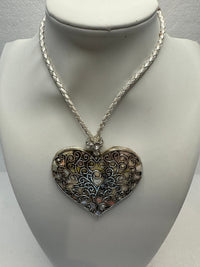 Silver filigree heart clay filled with patterned clay and on a leather braided cording necklace