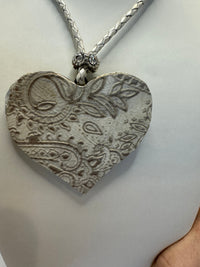 Silver filigree heart clay filled with patterned clay and on a leather braided cording necklace