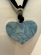 Silver filigree heart clay filled with patterned clay and on a black velvet necklace