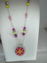 Round pendants filled with patterned polymer clay in various colors on dainty coordinated chains