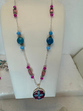 Round pendants filled with patterned polymer clay in various colors on dainty coordinated chains